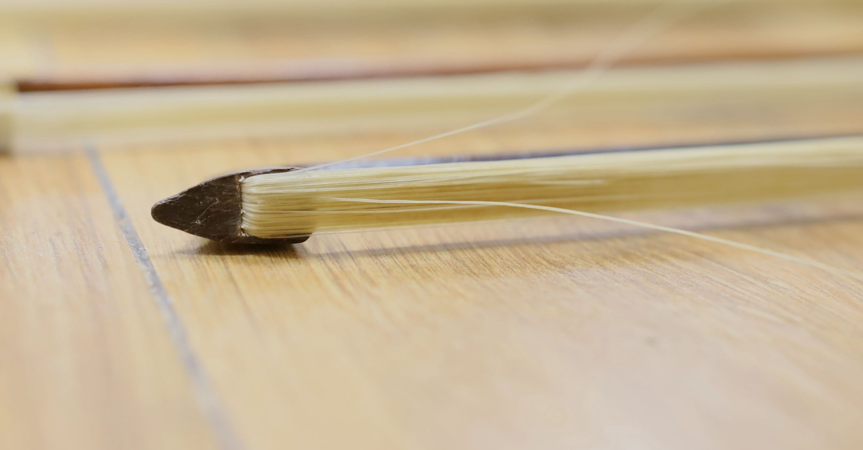 Three nickel mounted violin bows, one stamped R. R. Shields, two with ivory veneered tip - longest 75cm
